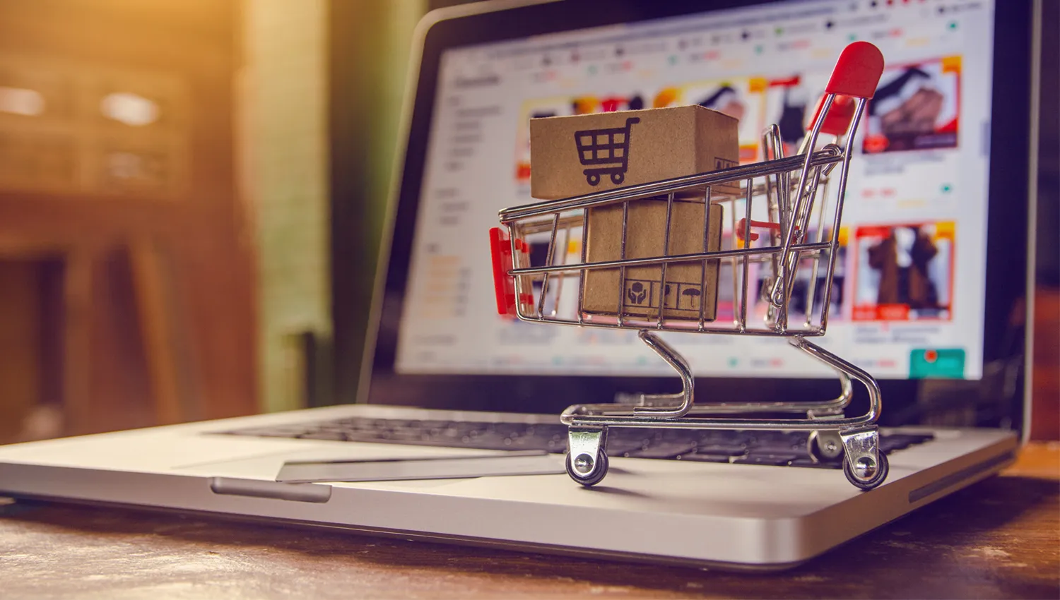 Shopping cart with parcels on a laptop keyboard, symbolizing secure e-commerce solutions and home delivery services